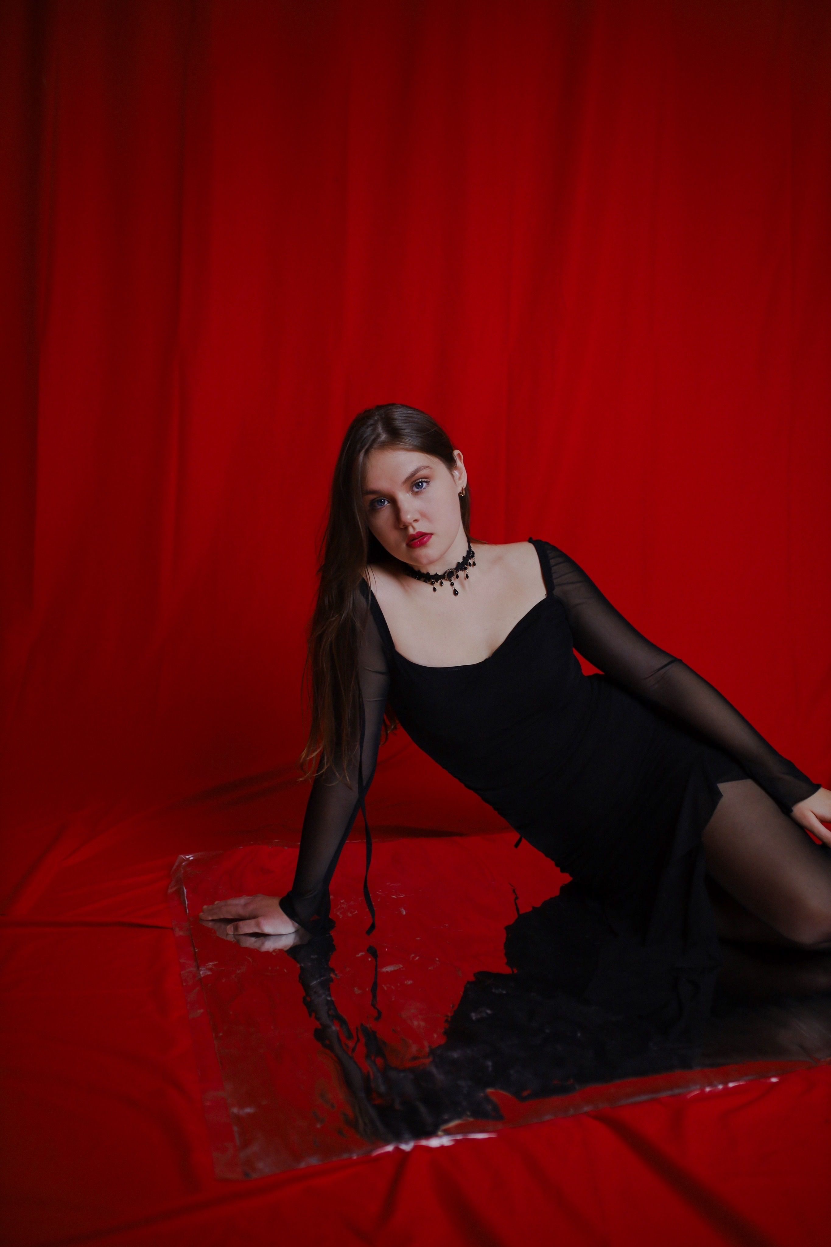 Elegant Woman in Black Dress on Red Background · Free Stock Photo