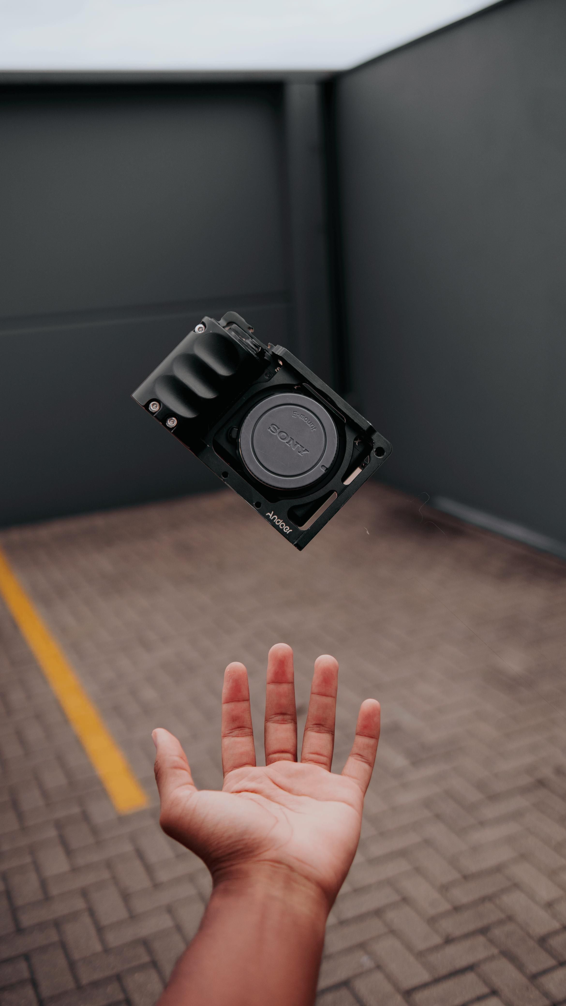 Floating Camera Above Hand in Urban Setting · Free Stock Photo
