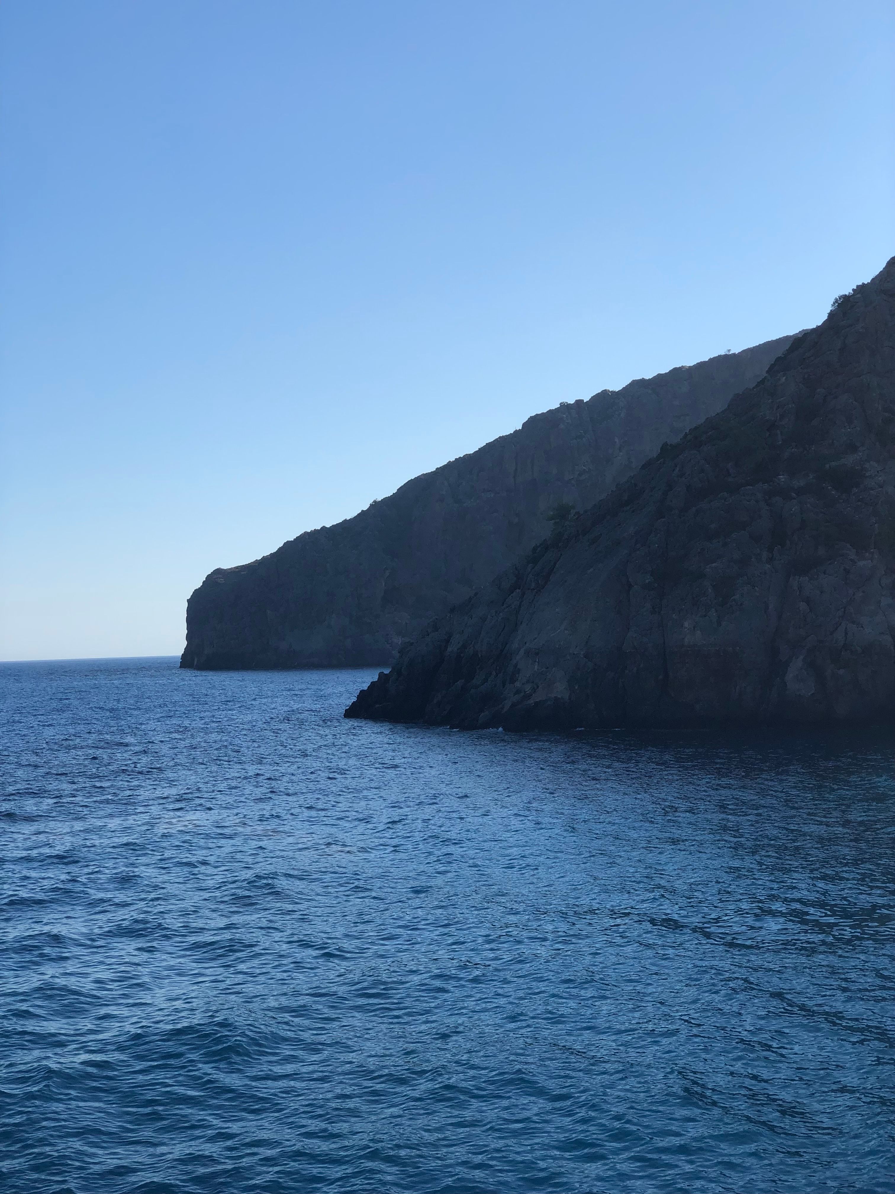 Serene Coastal Cliff View with Clear Blue Sea · Free Stock Photo
