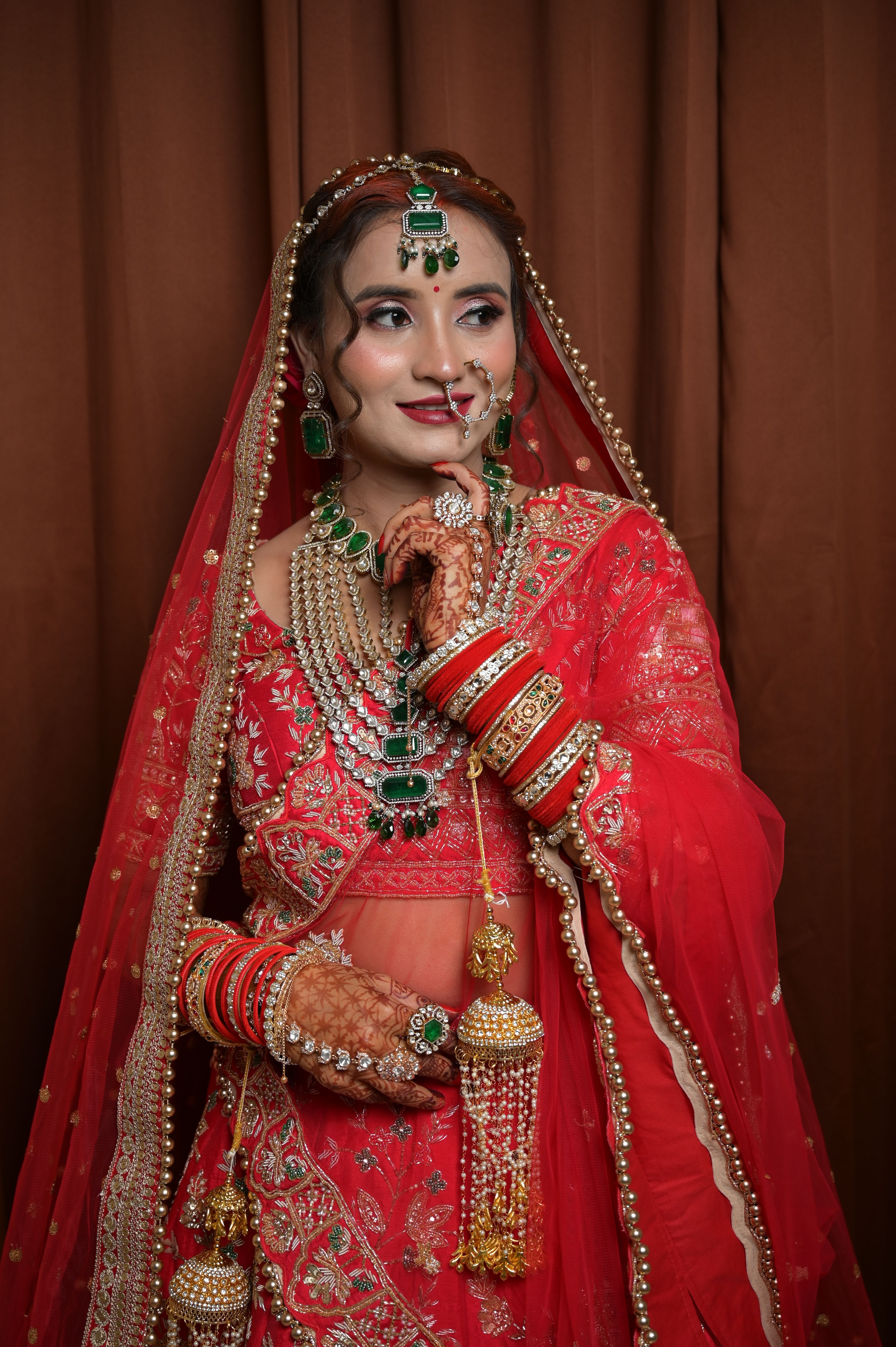 Beautiful Indian bride adorned in traditional red attire with intricate jewelry.