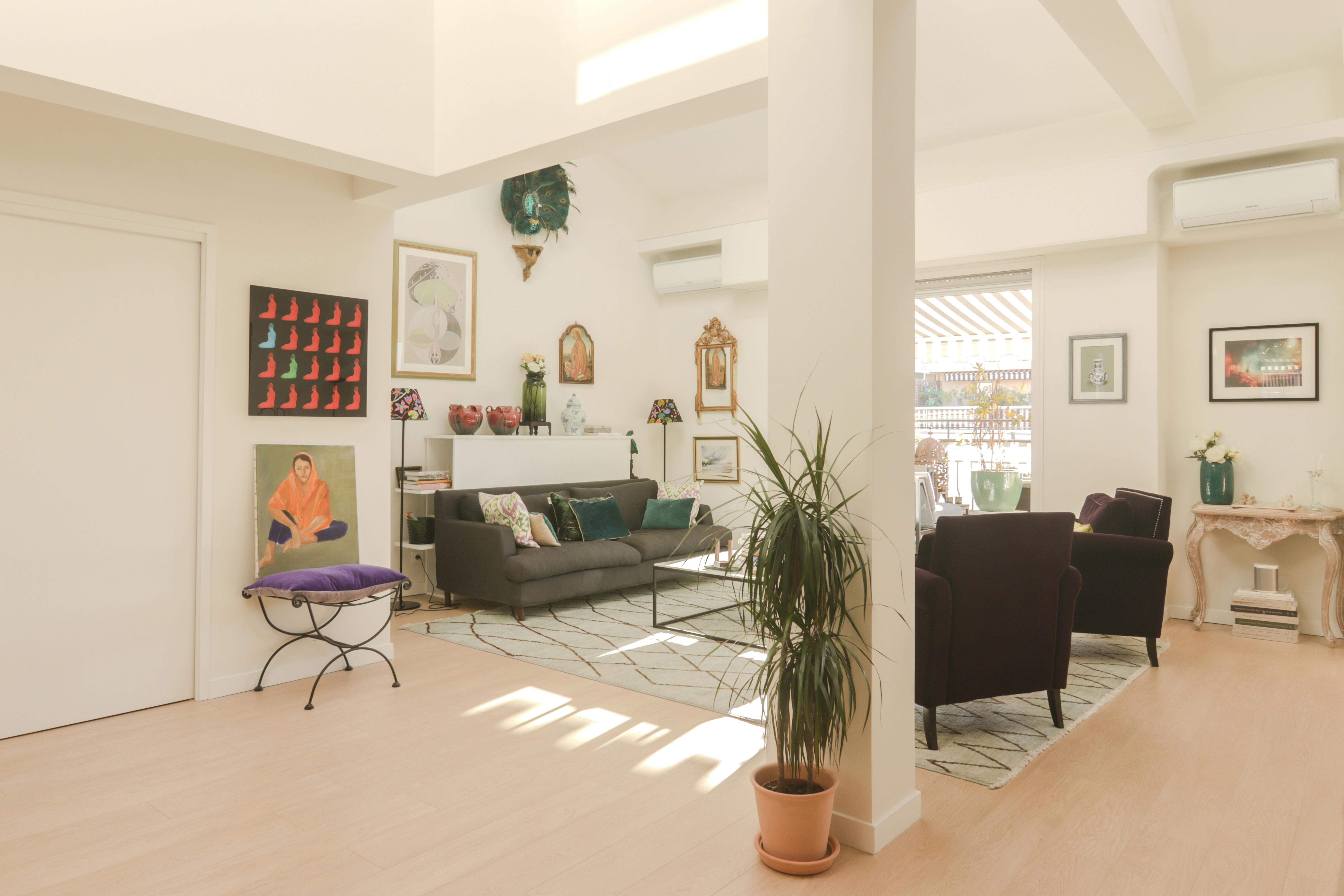A bright living room with art, plants and soft furniture, suggesting the promise of a room already thought through