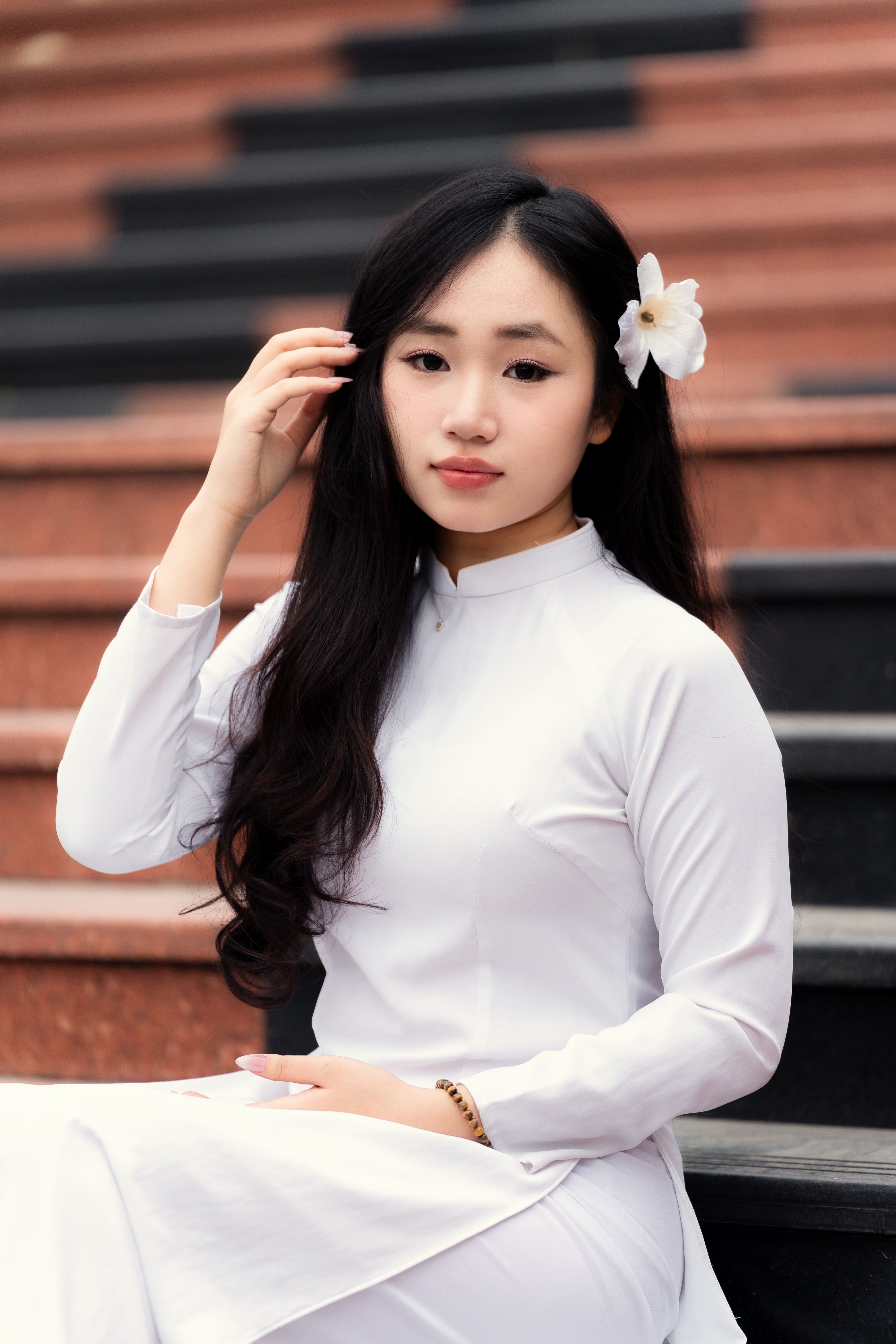 https://images.pexels.com/photos/30355838/pexels-photo-30355838/free-photo-of-young-woman-in-traditional-vietnamese-dress-on-steps.jpeg?auto=compress&cs=tinysrgb&dpr=1&w=500