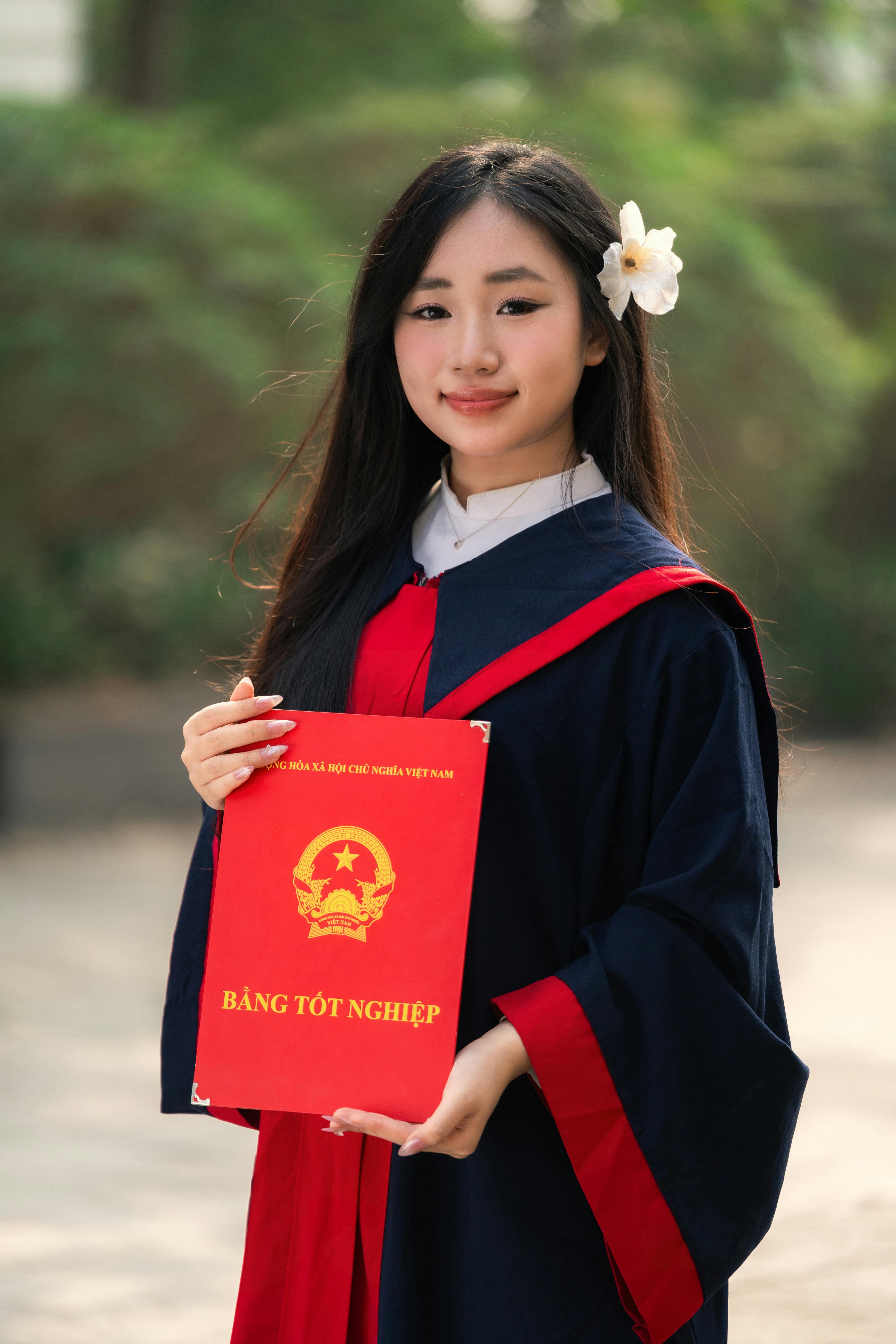Portrait of a young graduate in Hanoi, proudly holding her diploma.