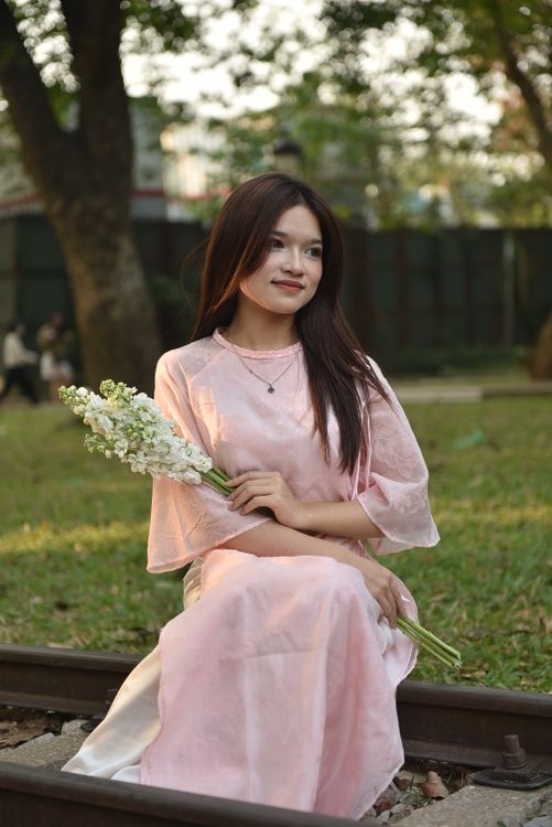 Young Woman in Pink Dress Holding Flowers Outdoors · Free Stock Photo