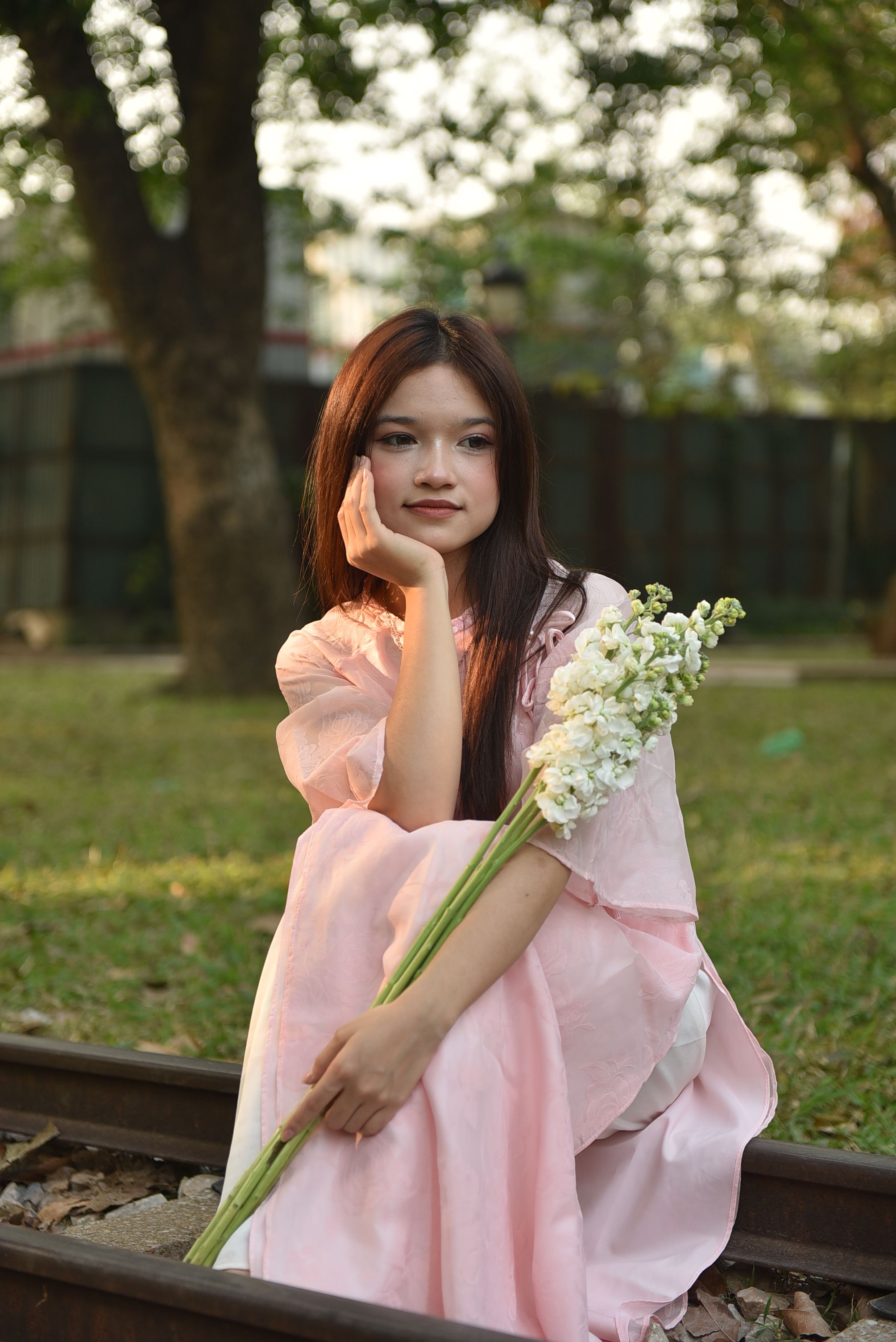Young woman in pink dress holding white flowers · Free Stock Photo