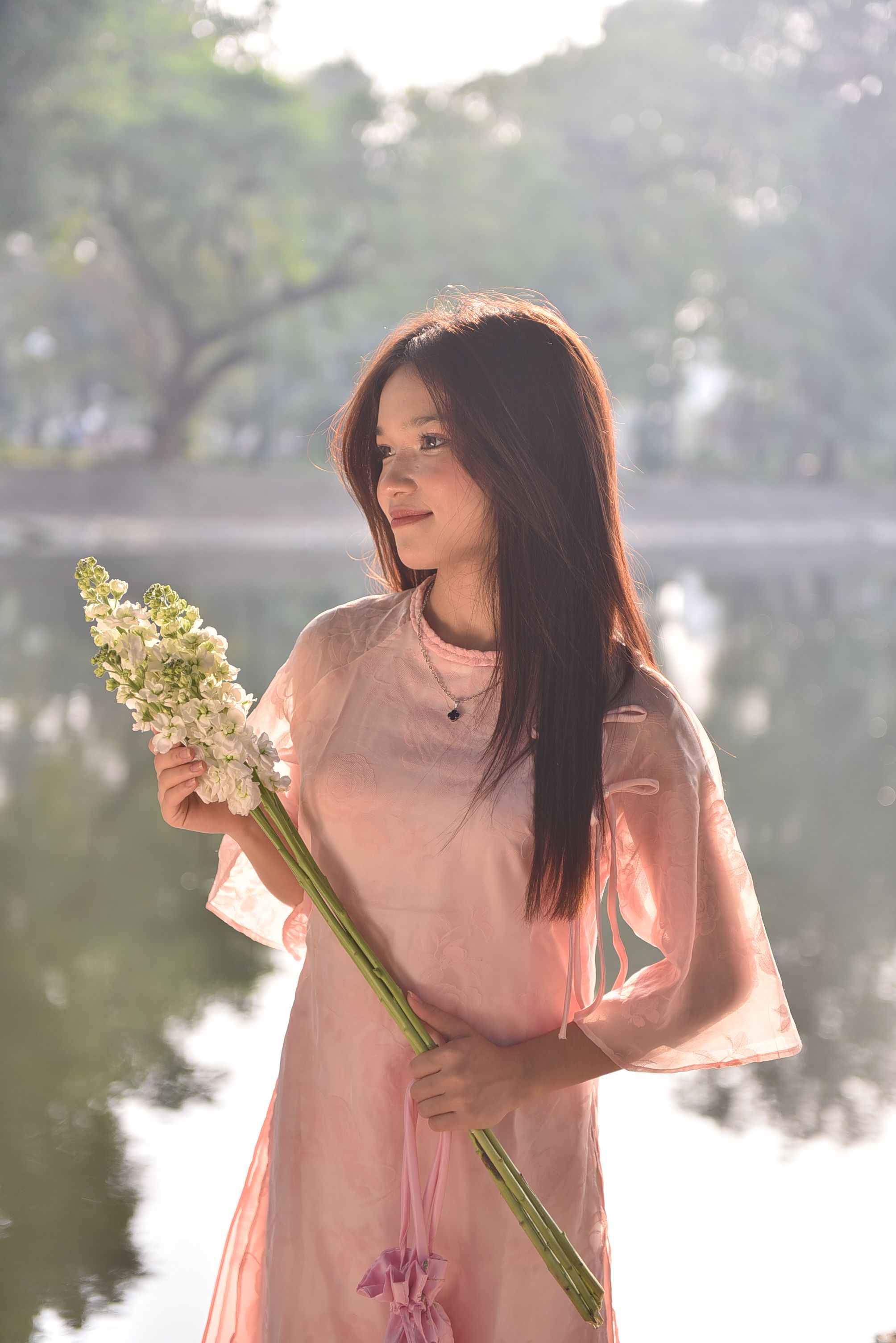 Woman in Pink Dress Holding Flowers by the Lake · Free Stock Photo