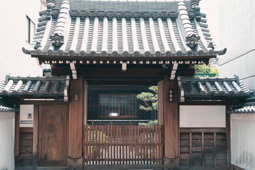 Wooden gate with traditional tiled roof in historic Kyoto, Japan.