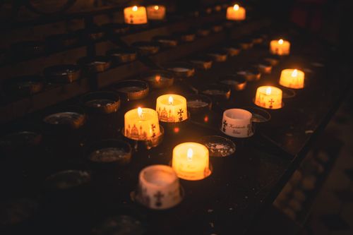 Free Warm glowing candles in a cathedral evoke a sense of faith and contemplation. Stock Photo