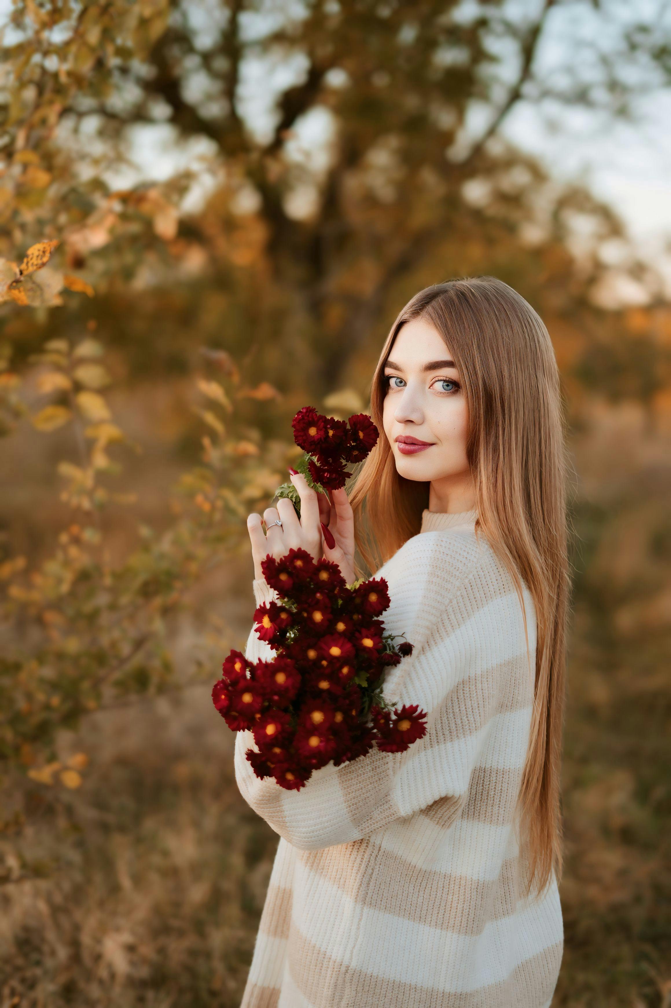 autumn portrait of woman holding red flowers