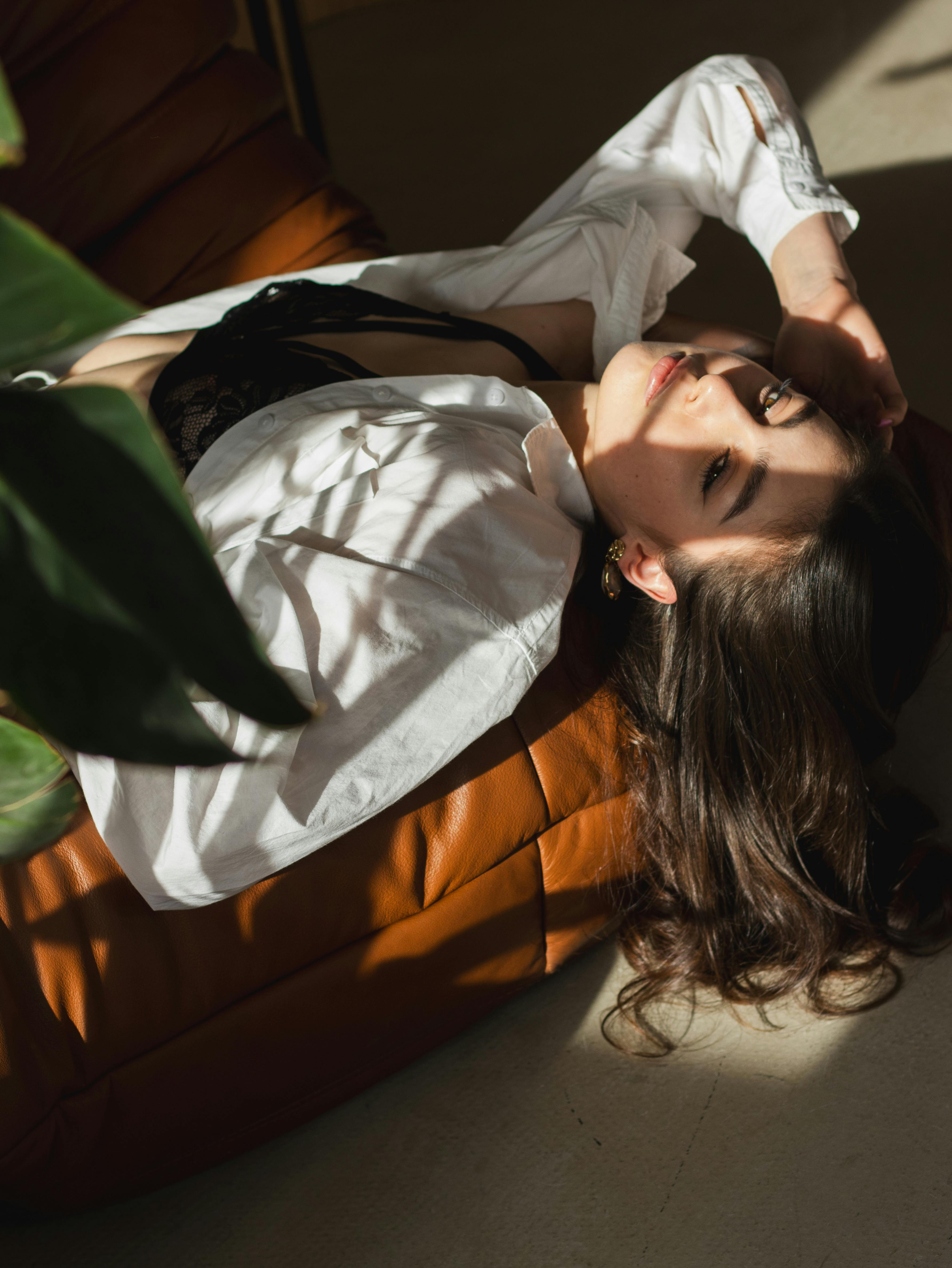 Woman relaxing indoors with sunlight creating artistic shadows. Warm and cozy ambiance in Poland.