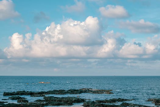 Peaceful coastal scene featuring rocks and sea under a bright blue sky in Bình Thuận, Vietnam.