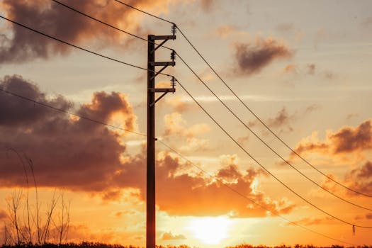 A beautiful sunset in Bình Thuận, Vietnam with silhouetted power lines against a vibrant sky.