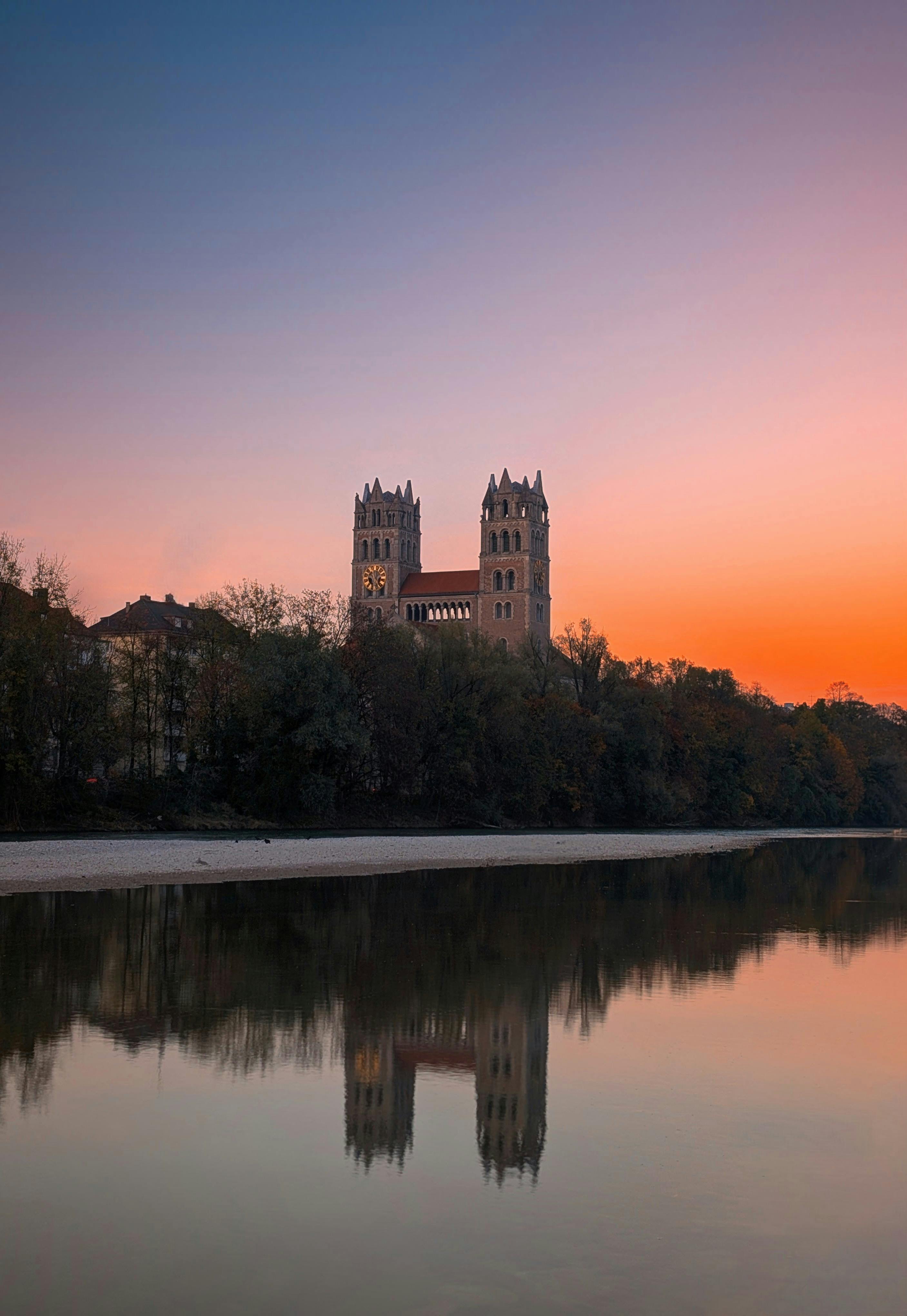 Stunning reflection of St. Maximilian Church during sunset in Munich, Germany.
