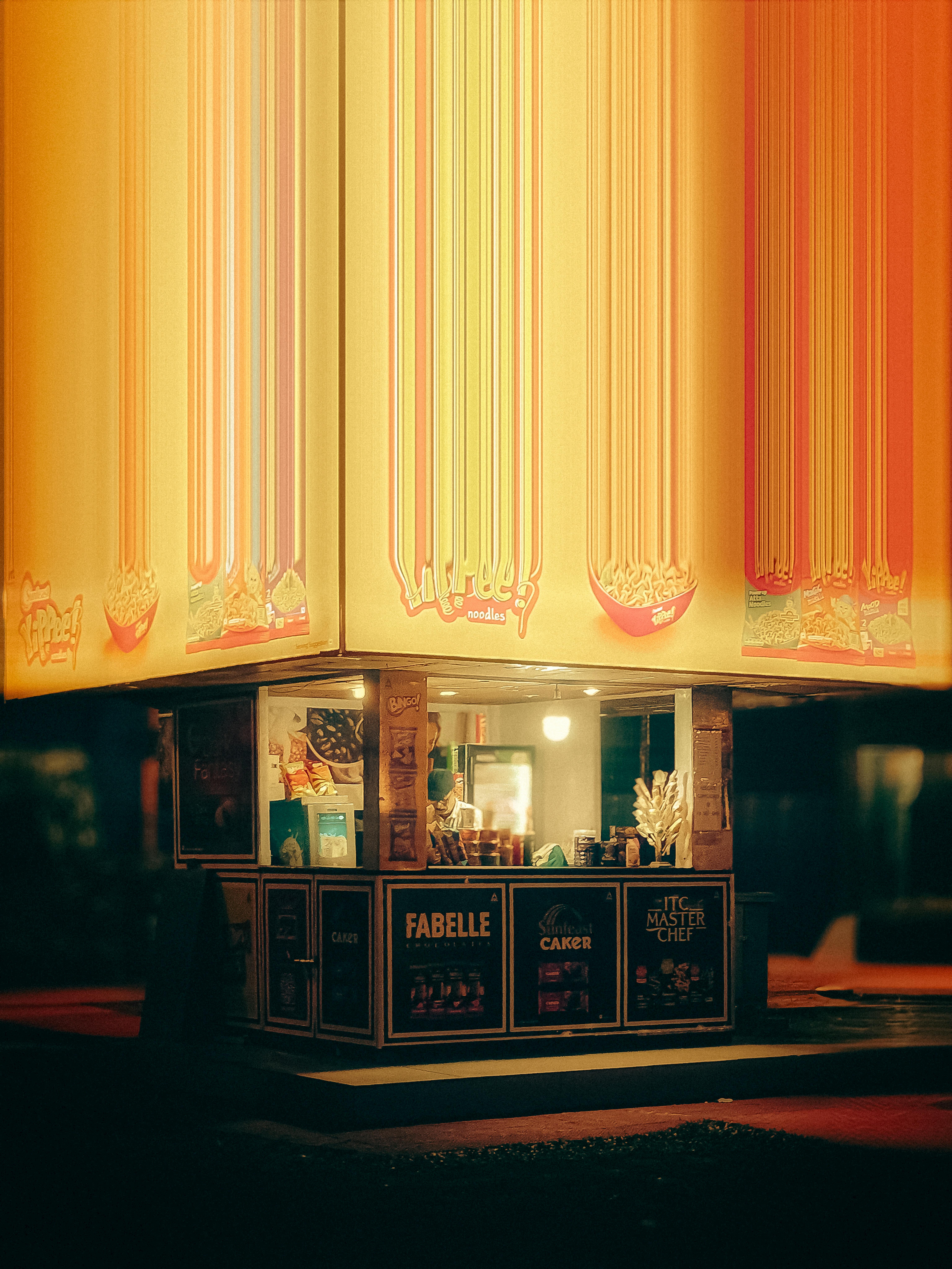 Gratis Un puesto de bocadillos iluminado y vibrante en Calcuta captura la esencia de la cultura de la comida callejera nocturna. Foto de stock