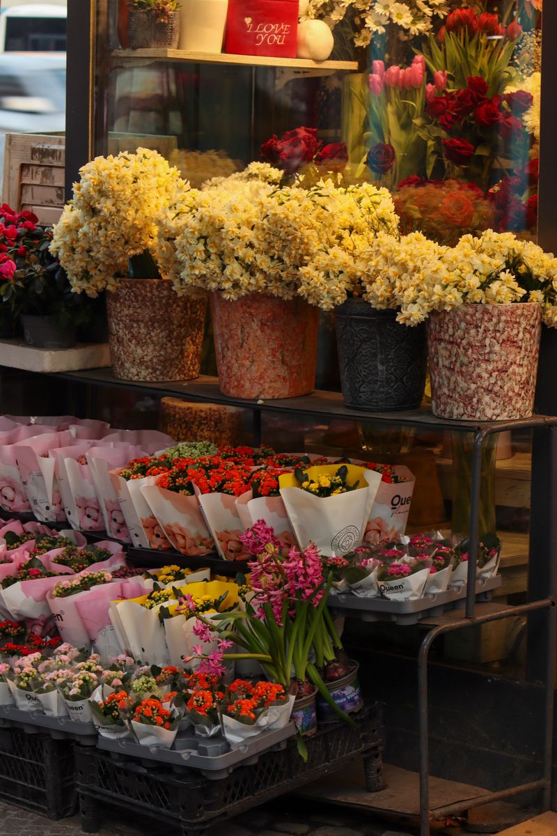 Beautiful assortment of colorful flowers displayed in pots and bouquets outside a shop.
