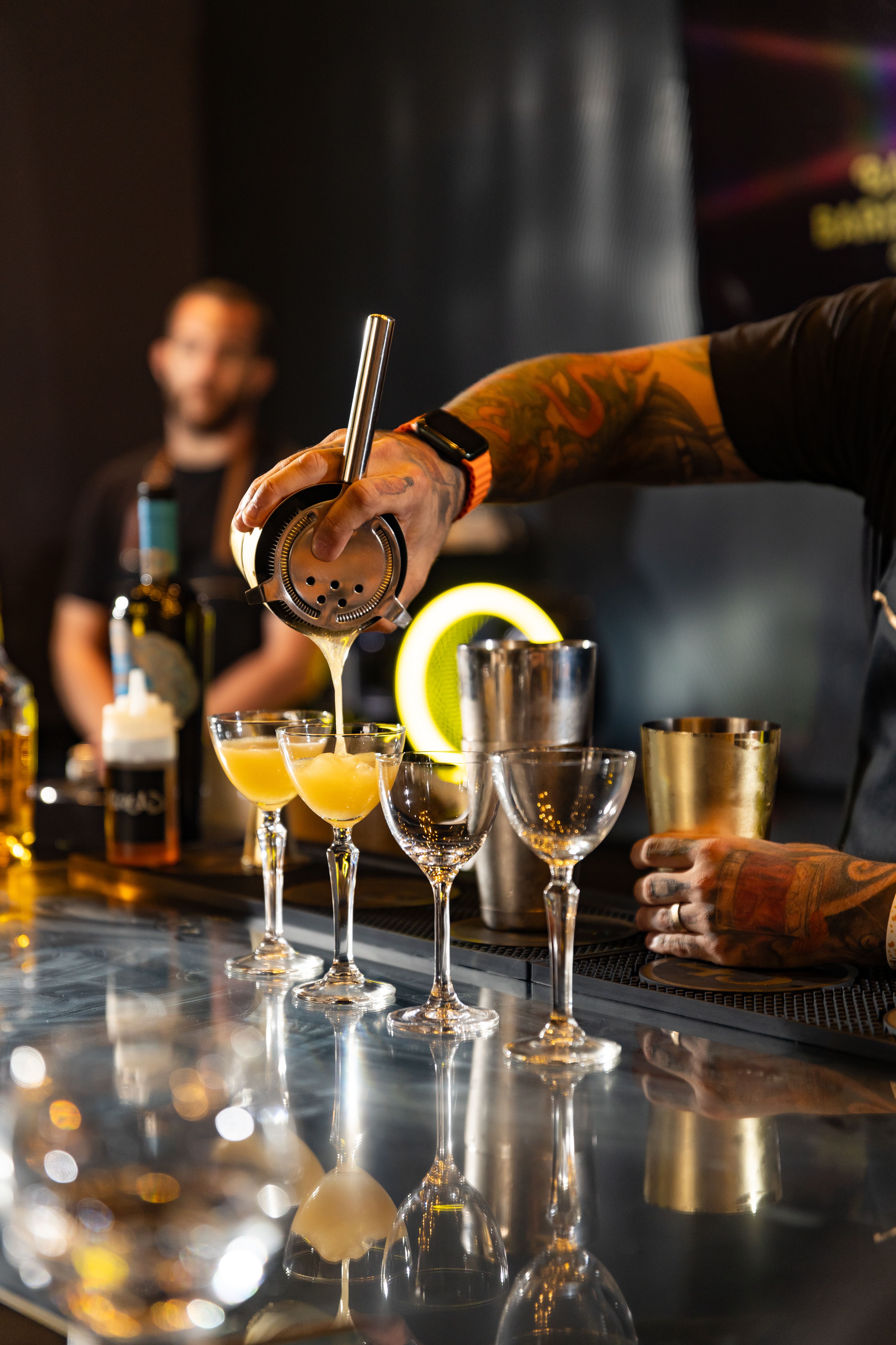Bartender pouring cocktails during a busy service