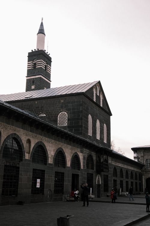 Free Historic mosque with distinctive architecture featuring arched windows and tall minaret. Stock Photo