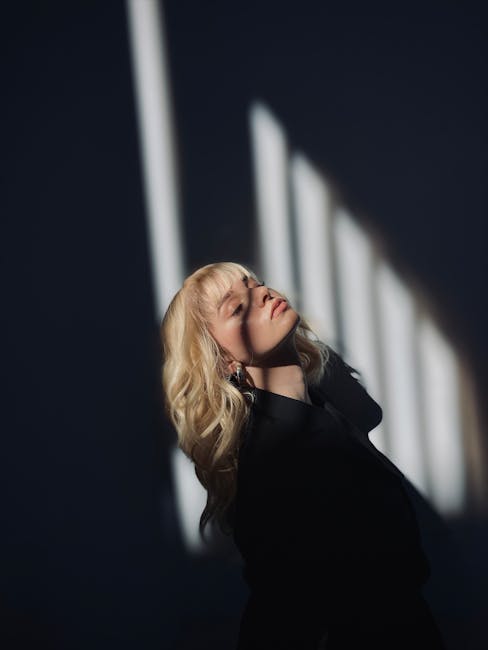 Portrait of a woman with blonde hair in striking shadows and dramatic lighting.