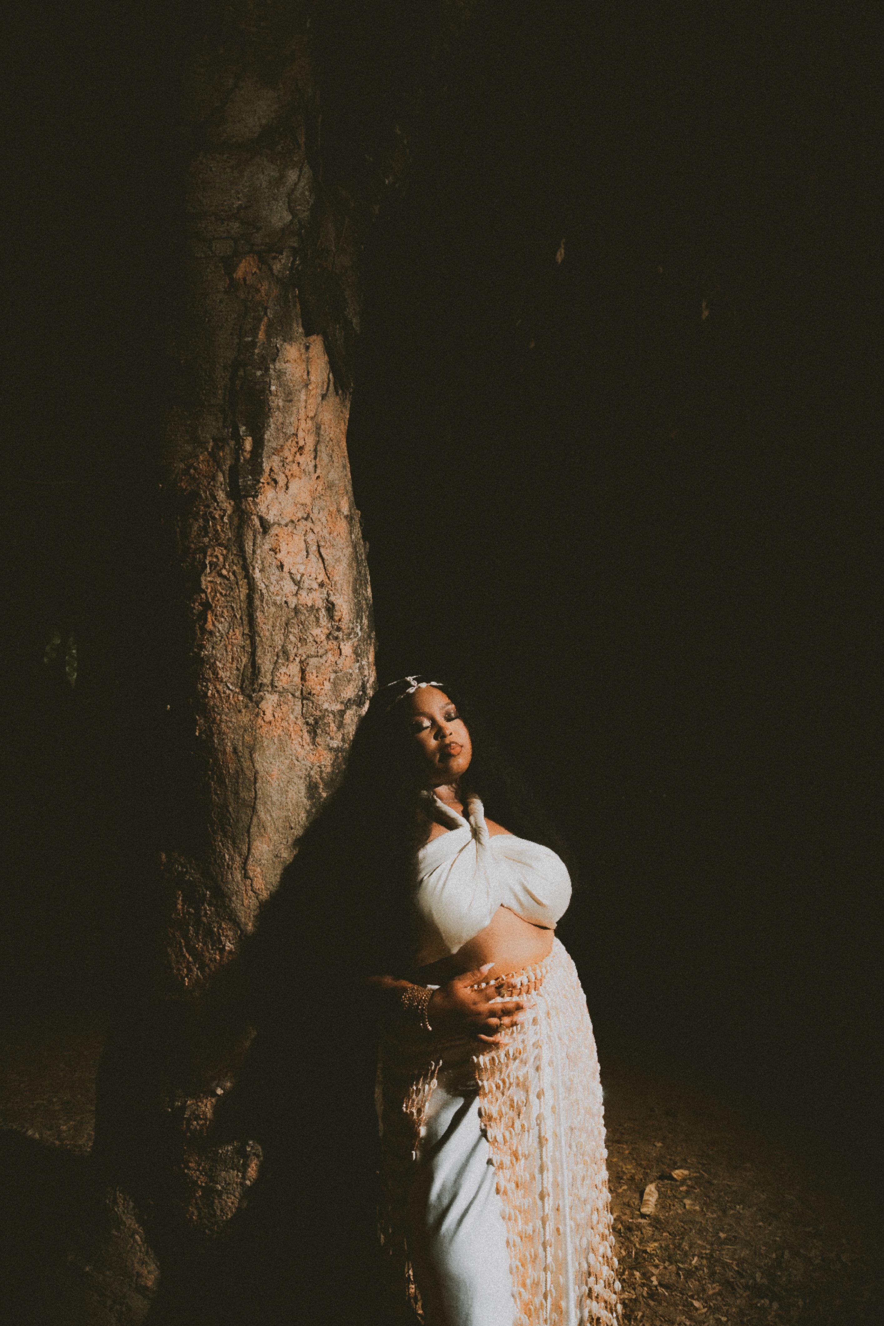 Serene Woman Leaning Against Tree at Night · Free Stock Photo