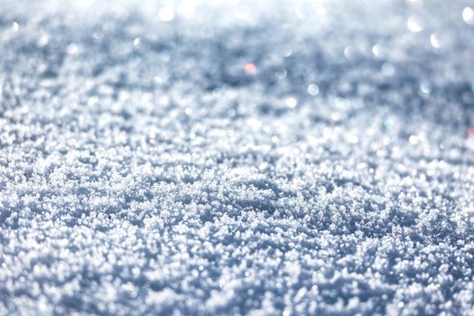 Detailed shot of sparkling snowflakes glistening in the sunlight, capturing winter's texture.