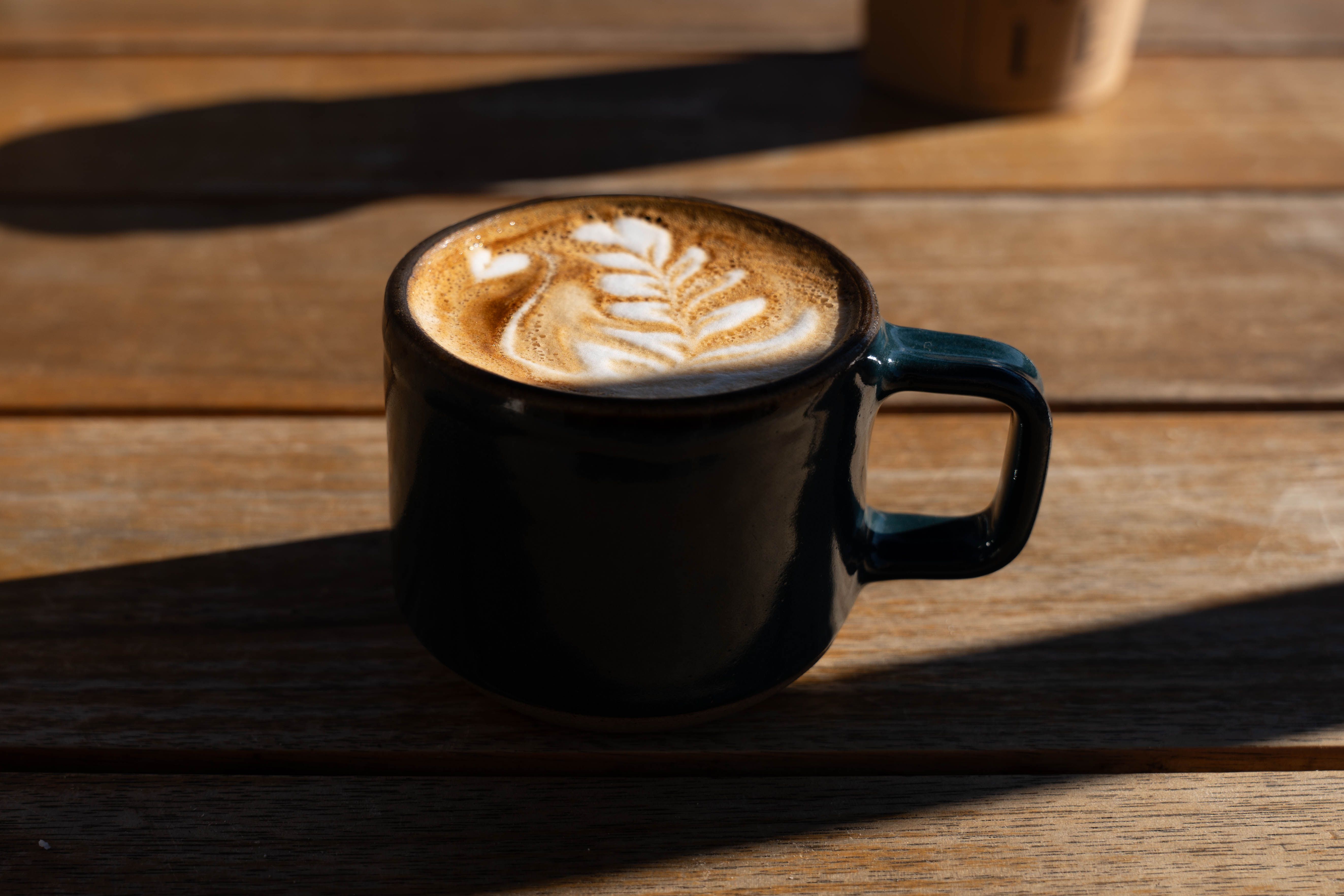 Flat white and pastry on a wooden table in a Reading independent cafe