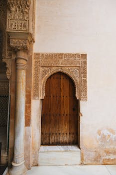Detailed archway in Alhambra, Granada, showcasing Moorish architecture and historical craftsmanship.