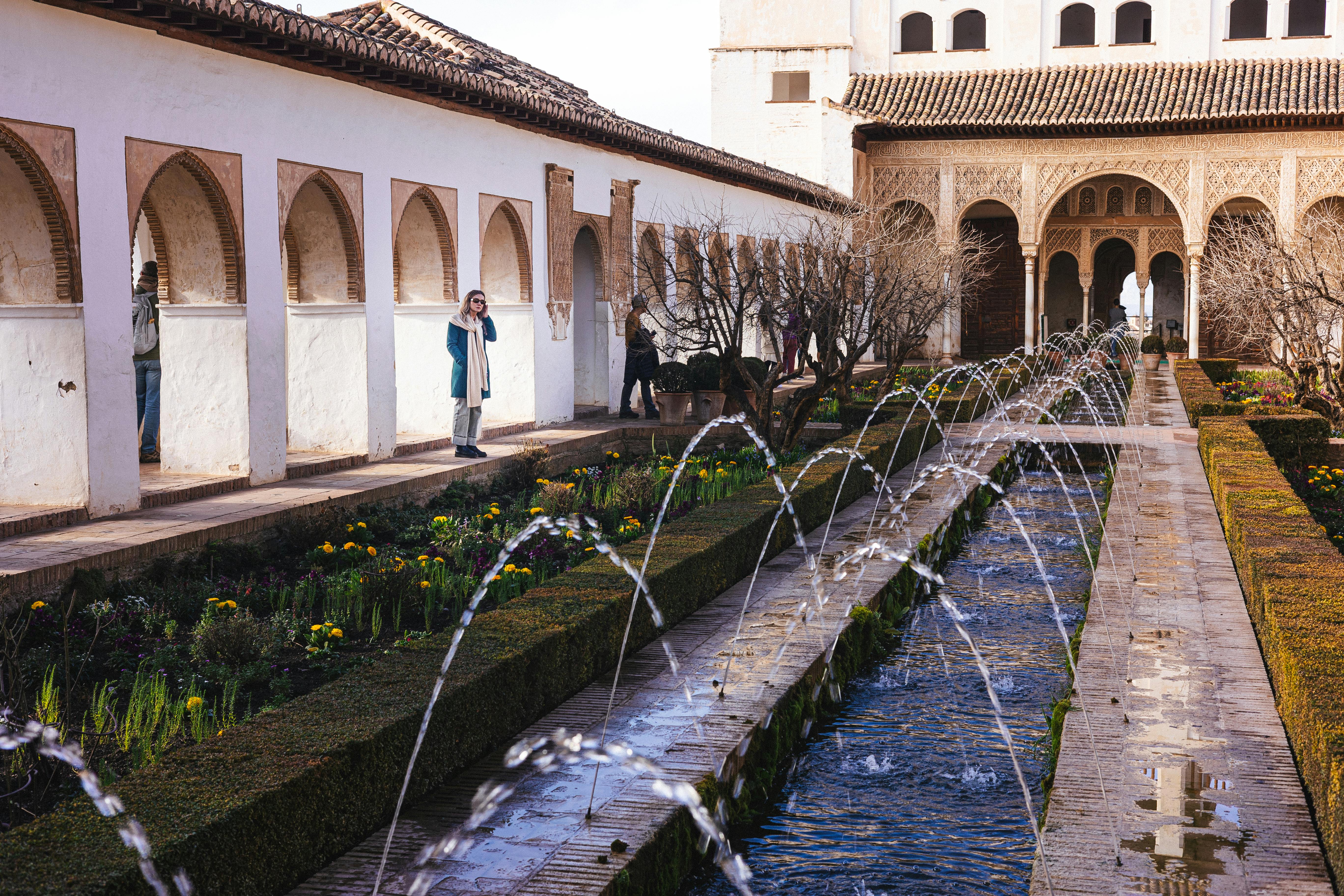 Captivating view of Alhambra's intricate architecture and lush gardens in Granada.