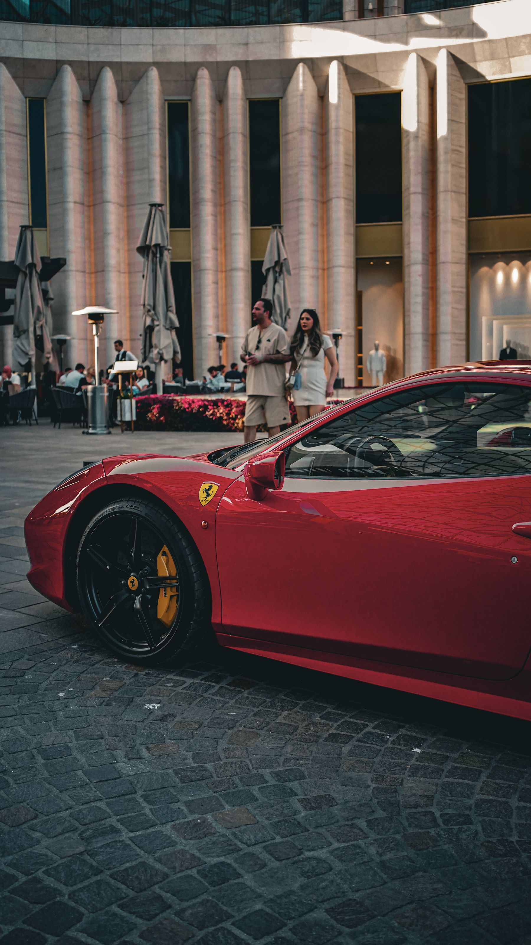 Red performance car outside contemporary architecture