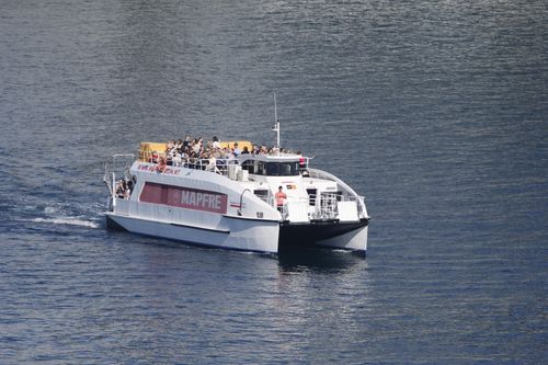 Free A ferry carrying passengers sails on calm waters, showcasing travel and leisure. Stock Photo