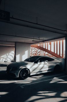 Sleek Mercedes-Benz car parked in a stylish shadowed urban location, exuding elegance and luxury.