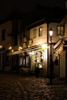 Charming night view of a cozy street cafe in North Macedonia with warm lighting.