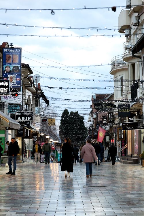 Free Vibrant street in Kuzey Makedonya with people, shops, and festive lights. Stock Photo