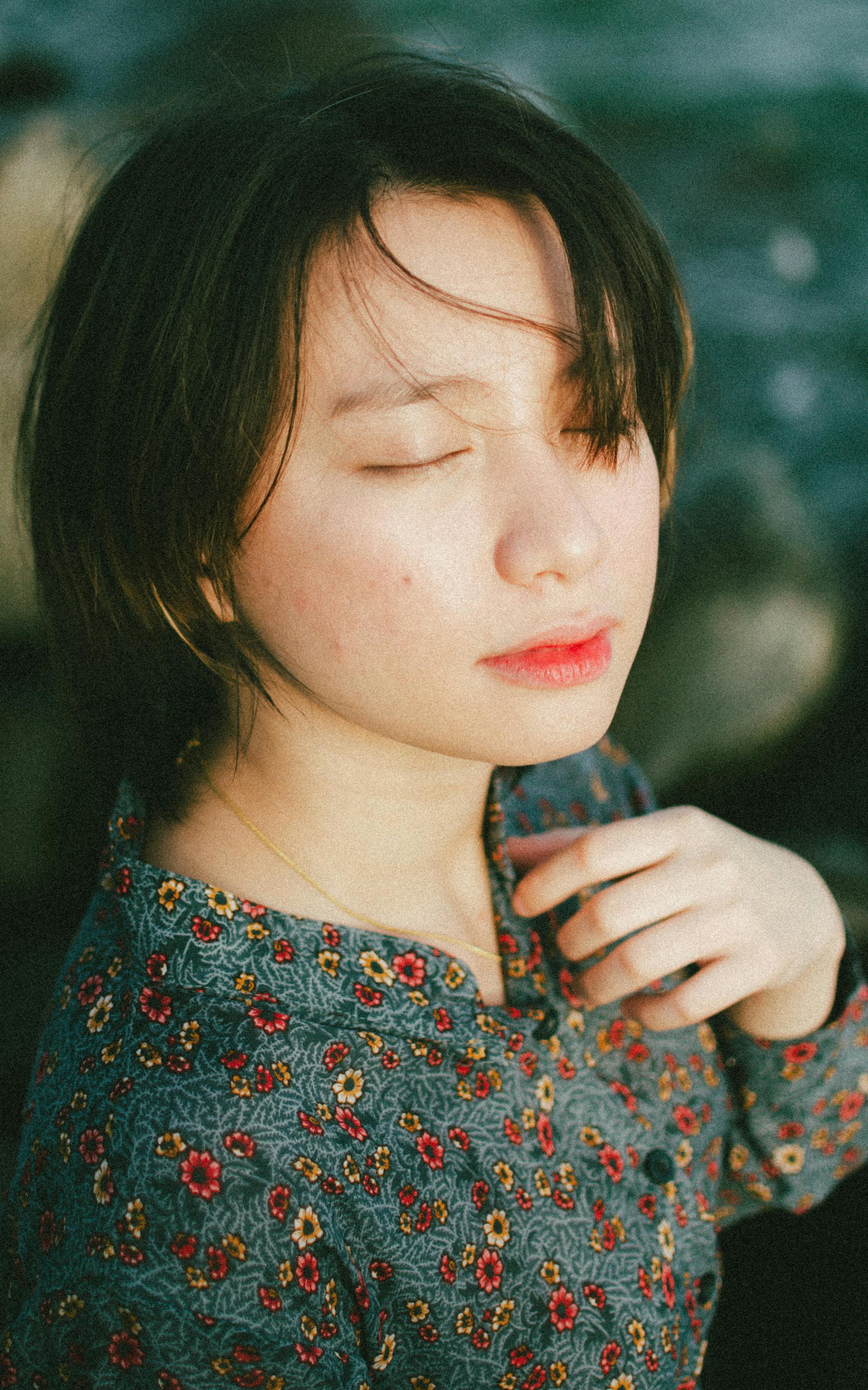Sensual close-up of woman's peaceful face, eyes closed, soft natural light highlighting relaxed surrender