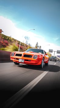 A dynamic shot of a vintage orange muscle car cruising on a highway in Ankara, Türkiye.