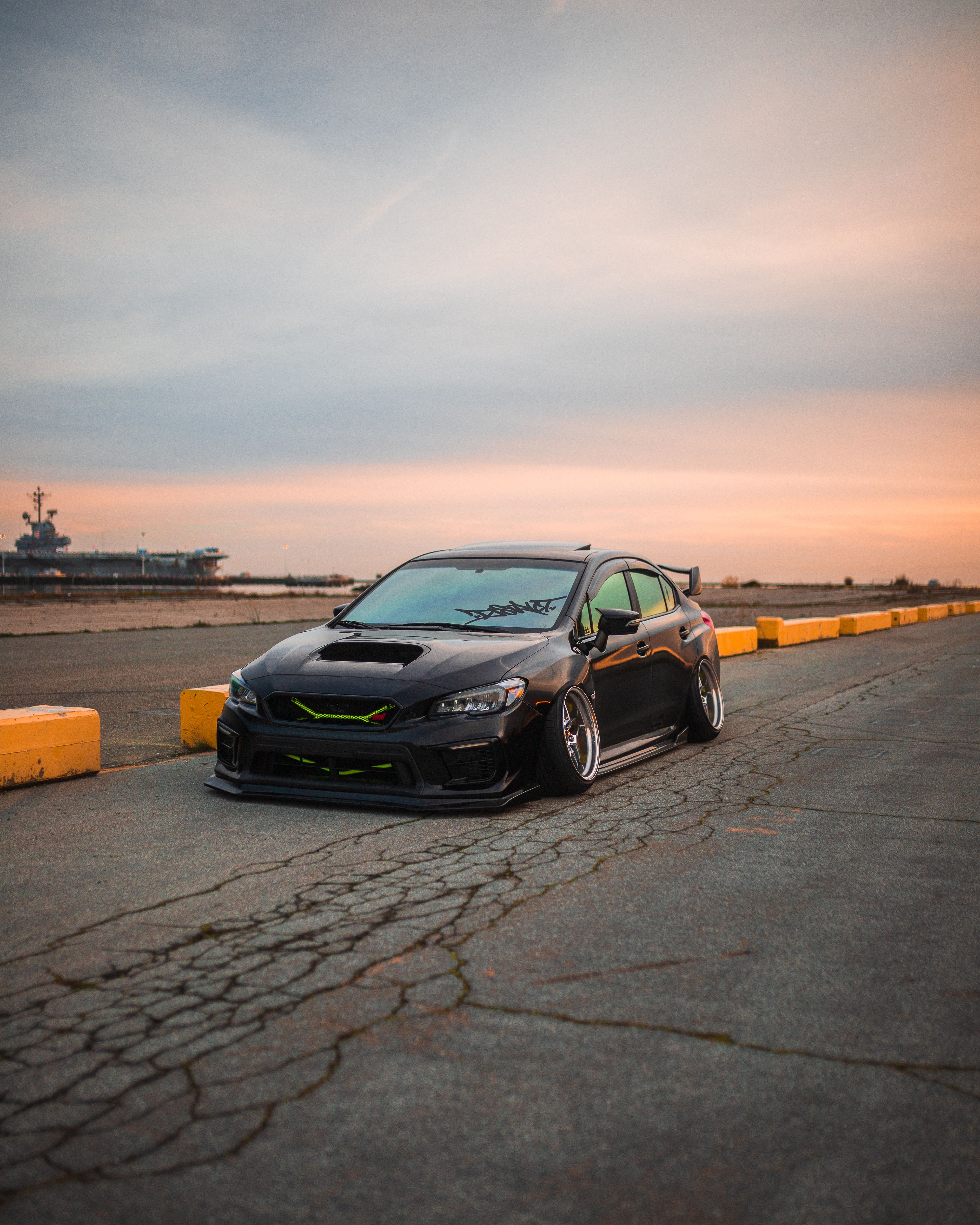 Sleek Black Car on Waterfront Road at Sunset · Free Stock Photo
