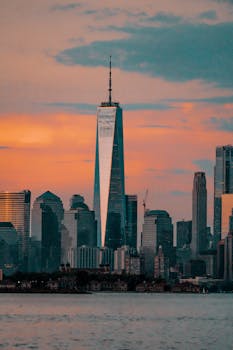 Silhouette of One World Trade Center during a vibrant New York City sunset.