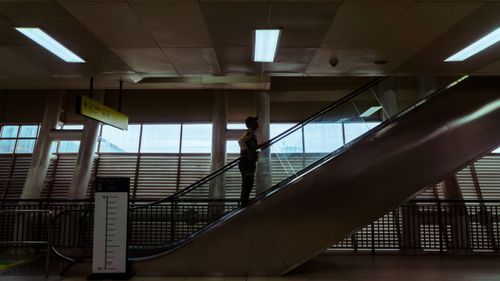 Free A silhouette of a man riding an escalator in an indoor setting in Jakarta. Stock Photo