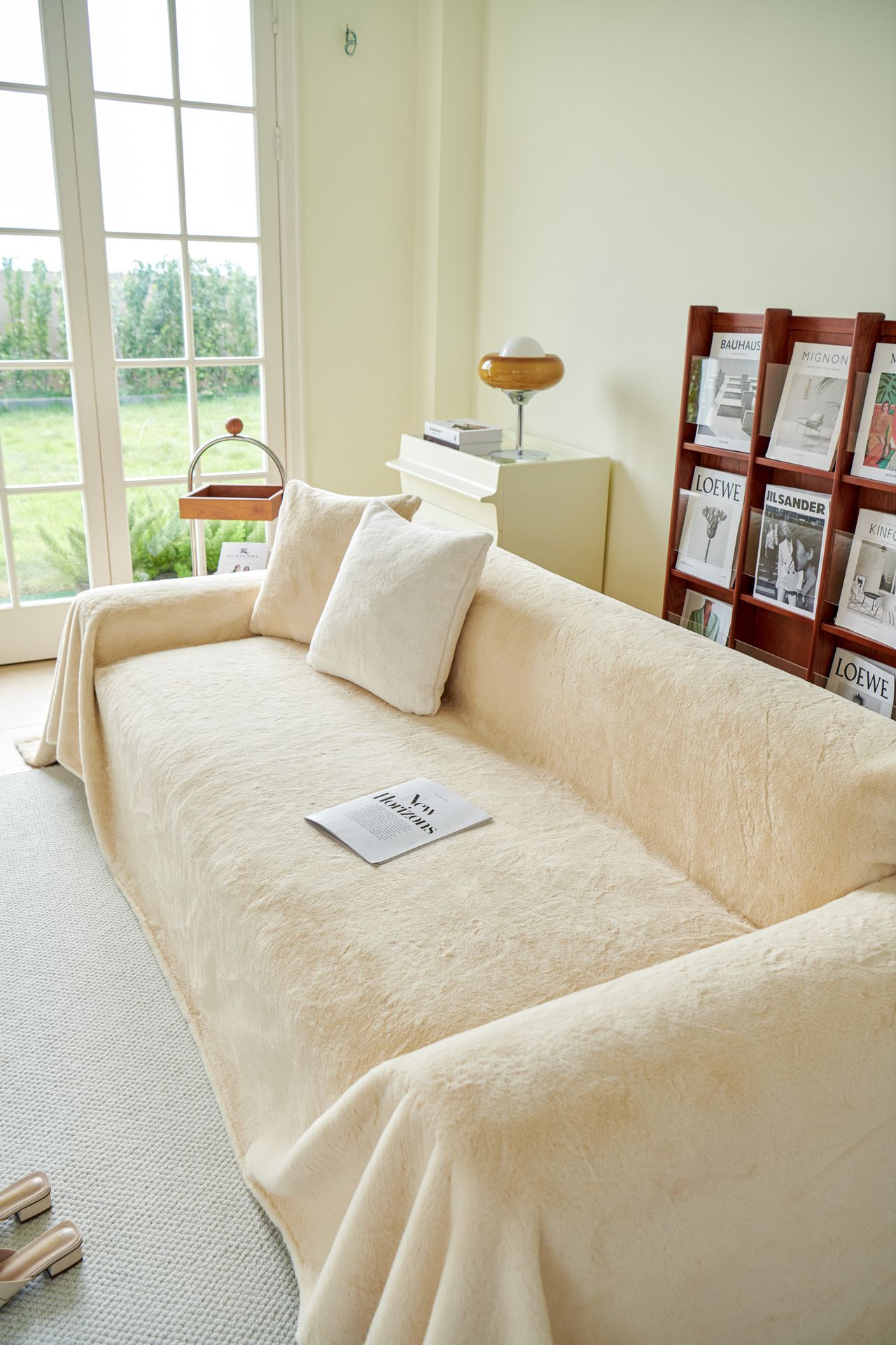 Cream slipcovered sofa with cushions beside a bright window