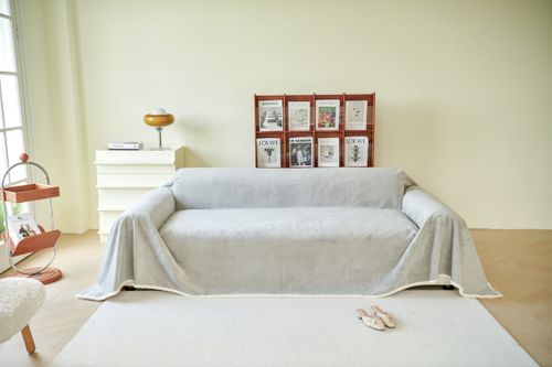 Free A minimalist living room featuring a sofa with a modern slipcover and stylish decor. Stock Photo