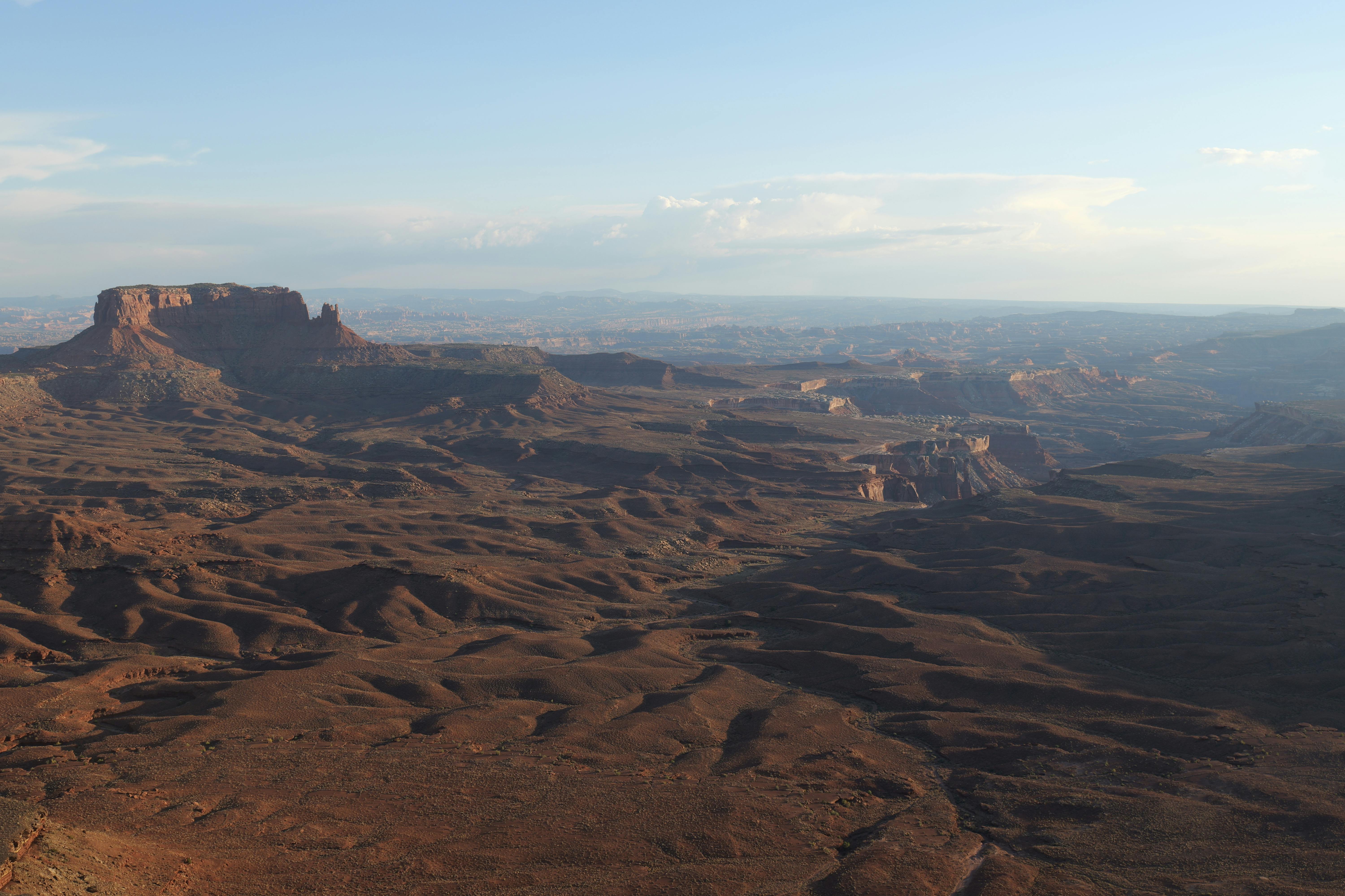 A stunning aerial view capturing the rugged terrain of Canyonlands National Park under a clear sky.