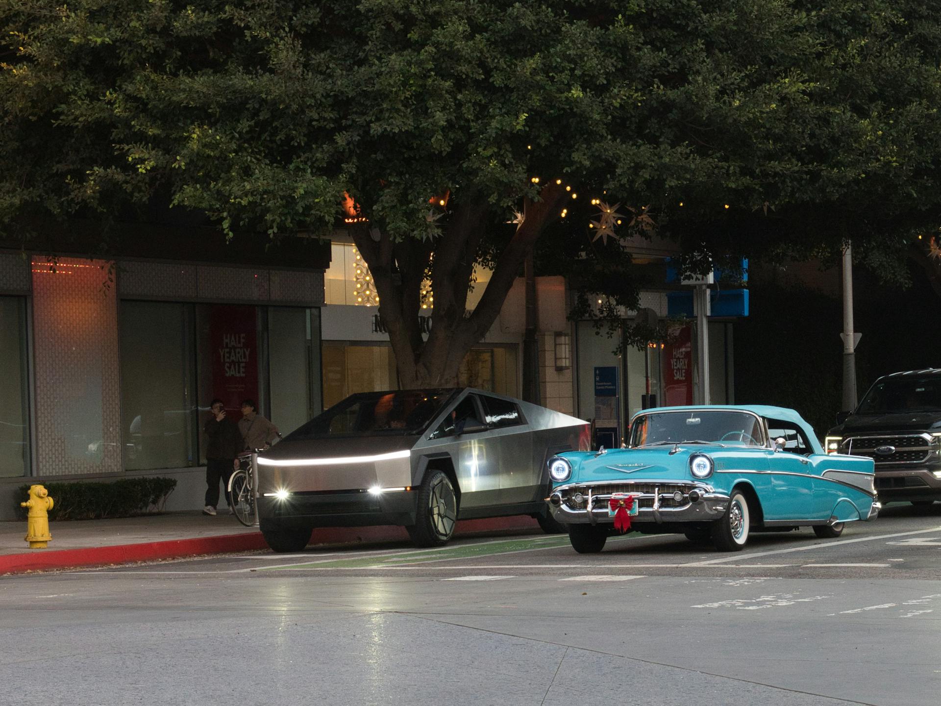 A vintage Chevrolet and a modern electric truck parked in Santa Monica.