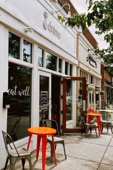 Cozy cafe exterior with vibrant red tables and inviting atmosphere.