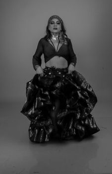 Black and white portrait of a woman in belly dance costume, exuding grace and strength.