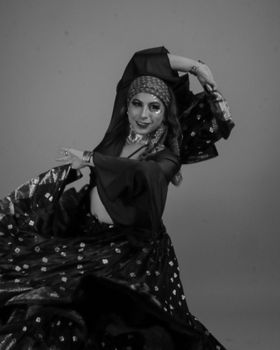 Dynamic black and white image of a traditional dancer in motion with elegant attire.