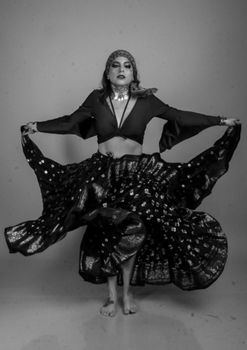 Black and white image of a woman performing Indian dance in traditional attire, showing movement and grace.