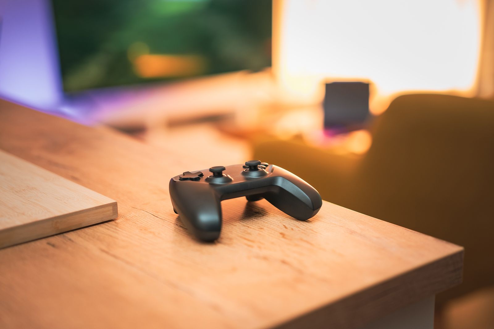 Modern gaming setup with a console controller, display and ambient lighting