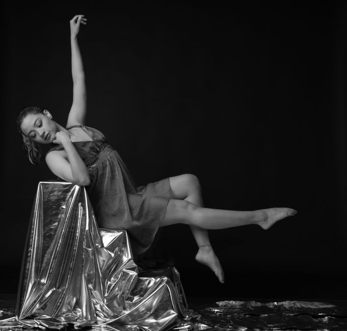 A graceful contemporary dancer posed artistically in a black and white setting.