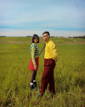 Vibrant fashion portrait of a couple standing in a lush Moroccan field.