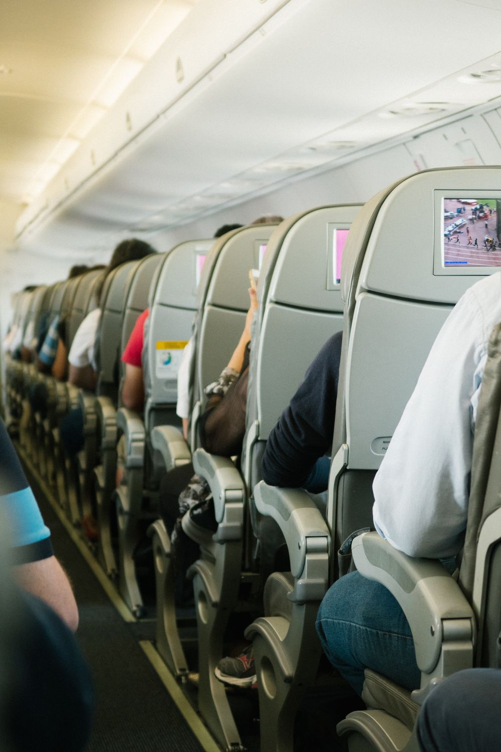Passengers seated in an airplane cabin, economy class travel on a long-haul flight Passengers seated in an airplane cabin, economy class travel on a long-haul flight
