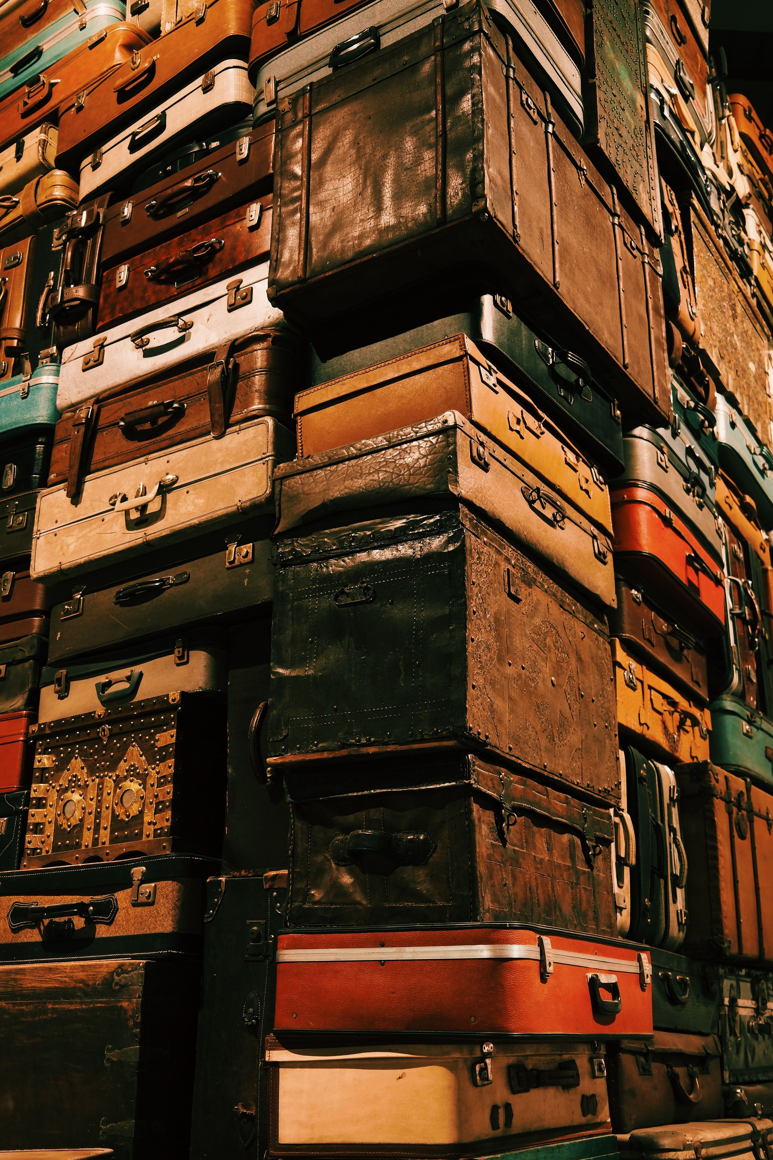 Towering pile of vintage suitcases representing travel and nostalgia.